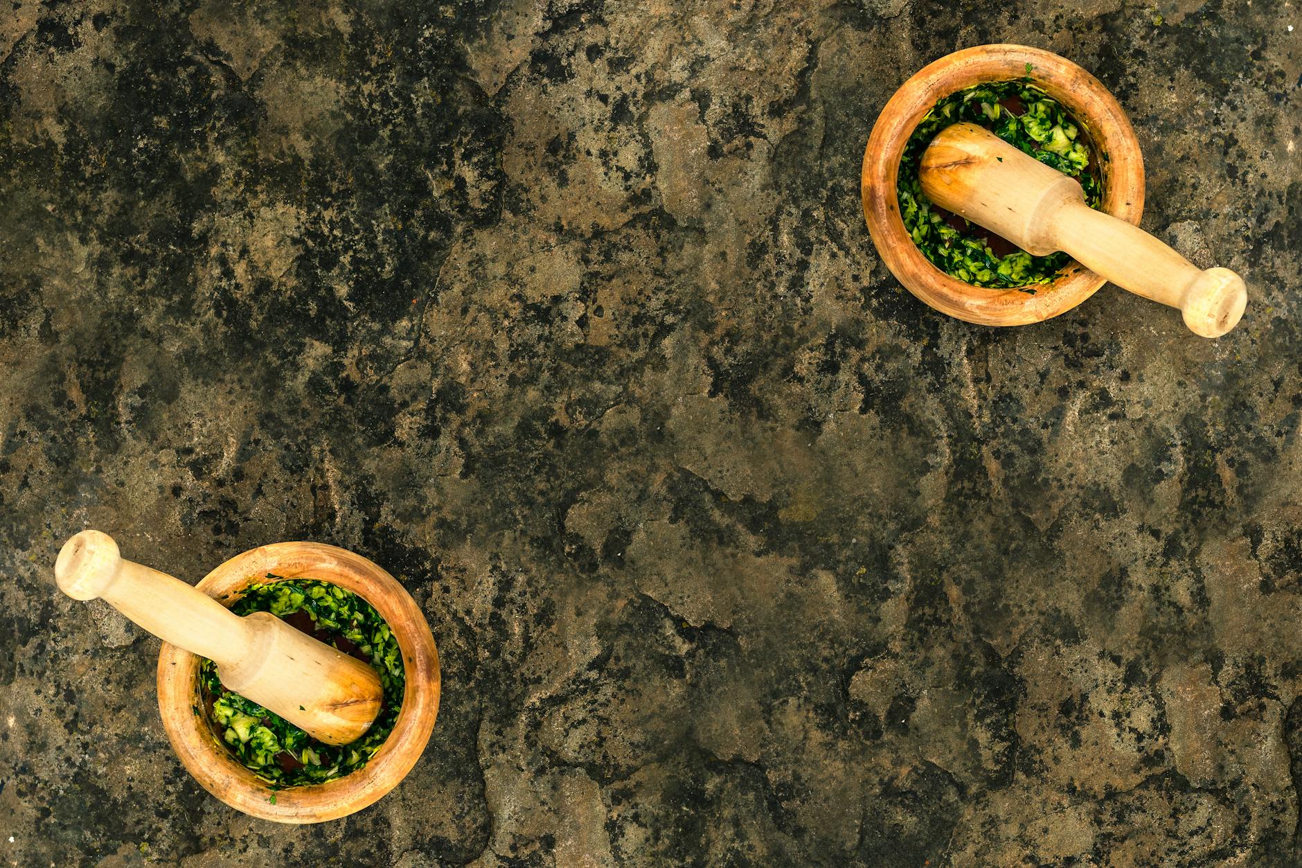 Drewniane moździerze z zielonym pesto widziane z góry