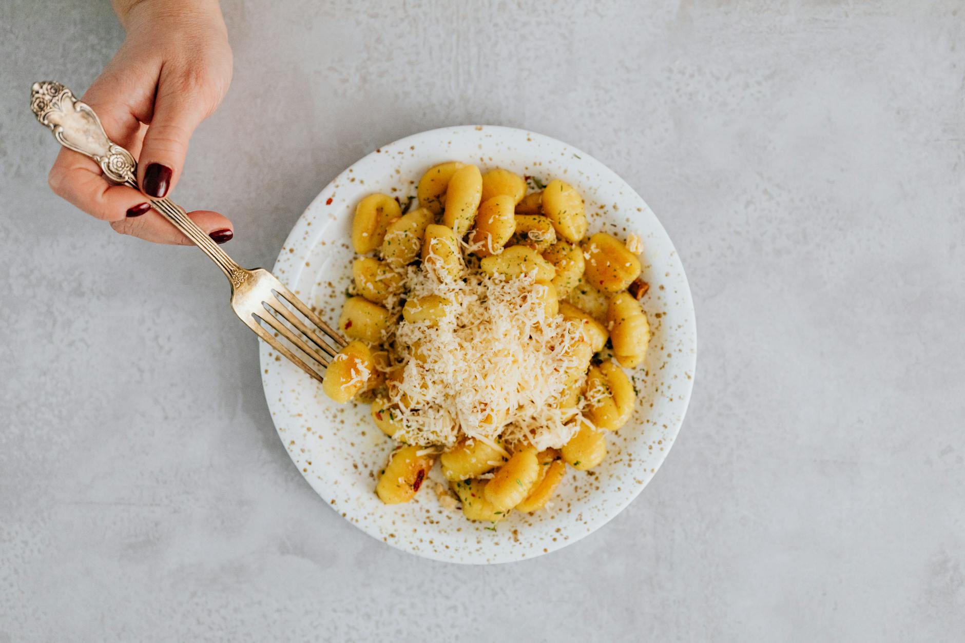 Gnocchi z batatów w sosie pomidorowym z oregano i parmezanem na talerzu