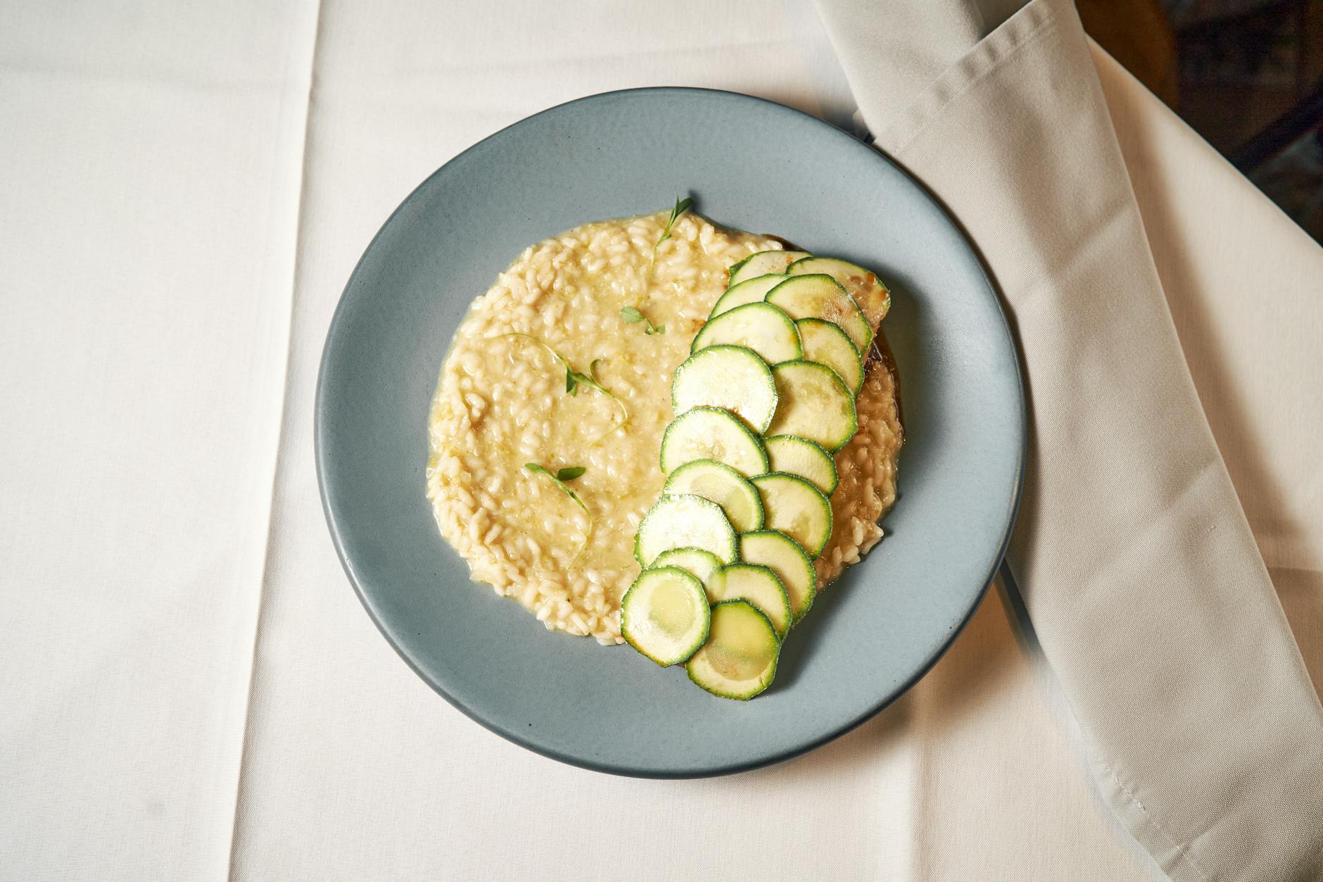 Kremowe risotto z plasterkami cukinii na elegancko nakrytym stole