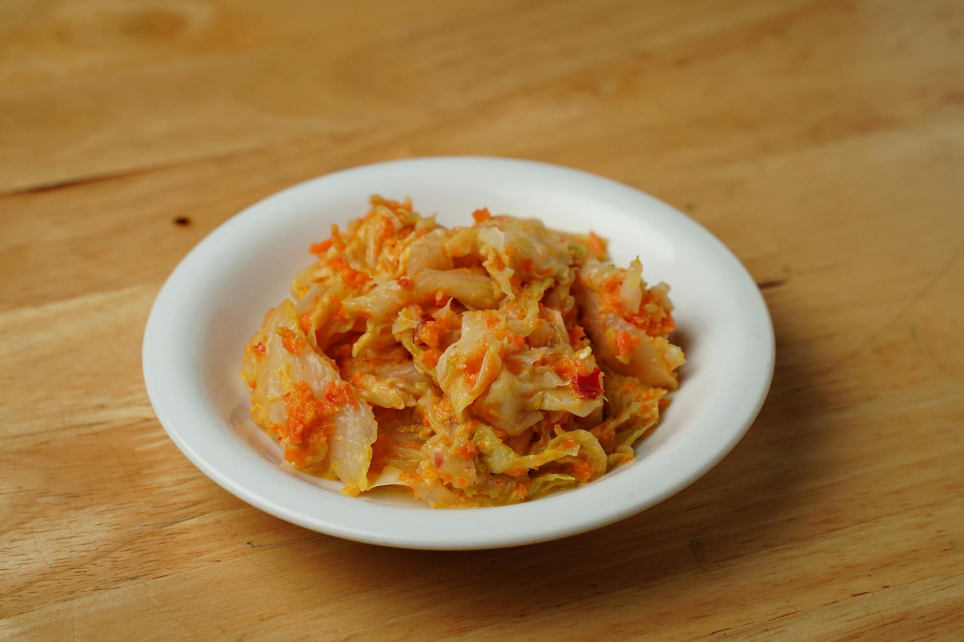 Miska pikantnego kimchi z kapusty na drewnianym stole