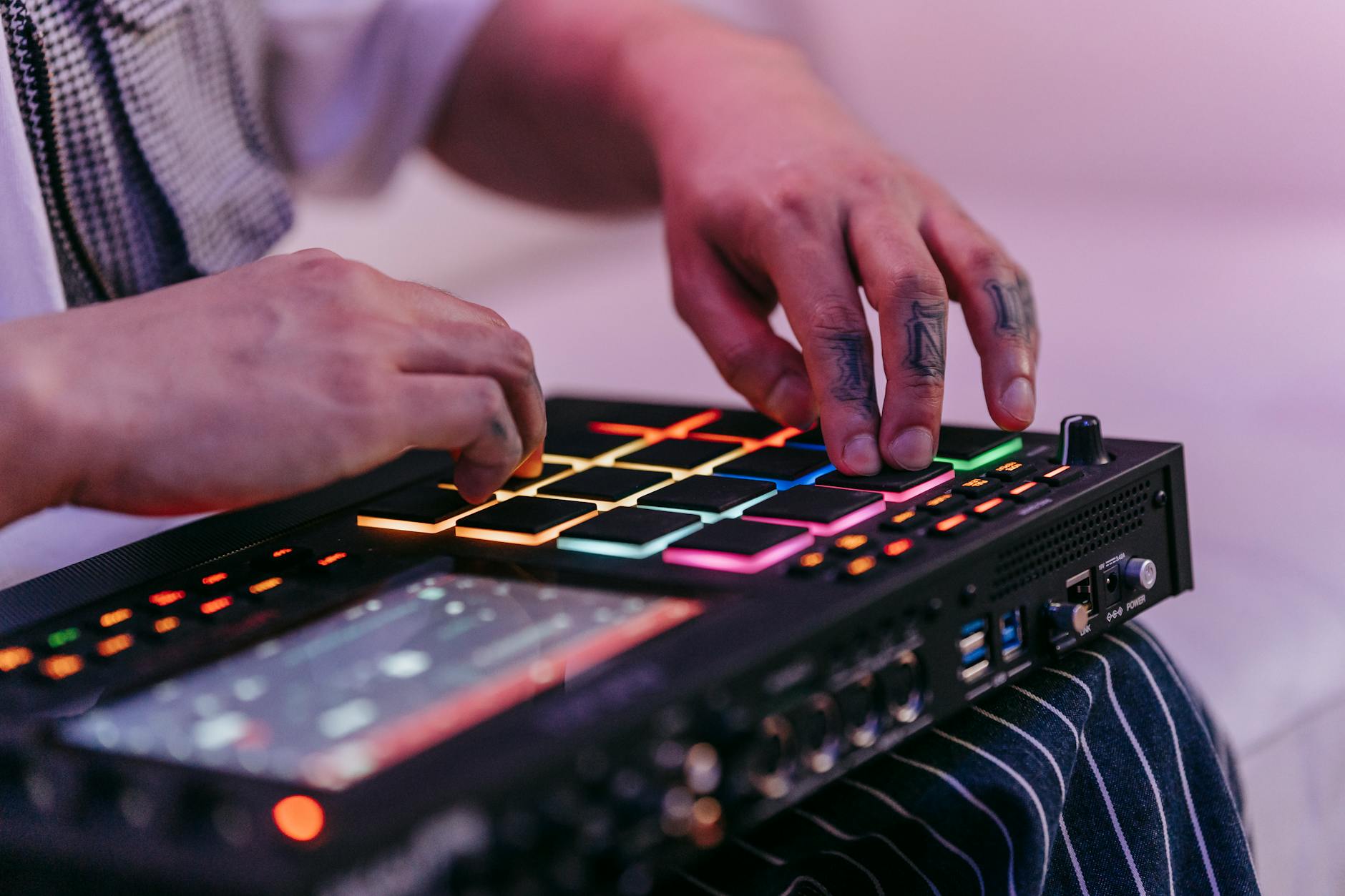 Wytatuowane dłonie programują kolorowy sekwencer muzyczny