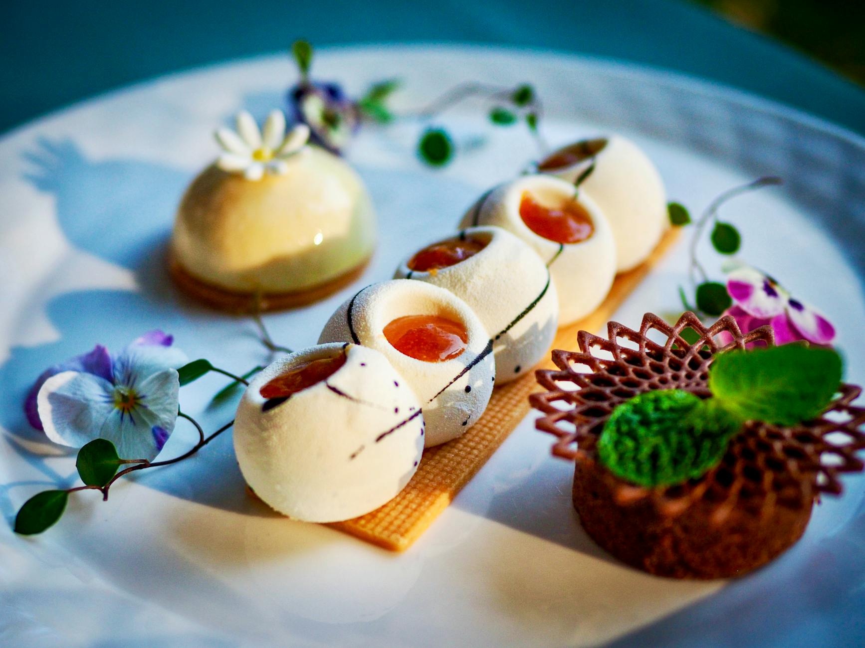 Wykwintny deser restauracyjny z jadalnymi kwiatami na eleganckim talerzu