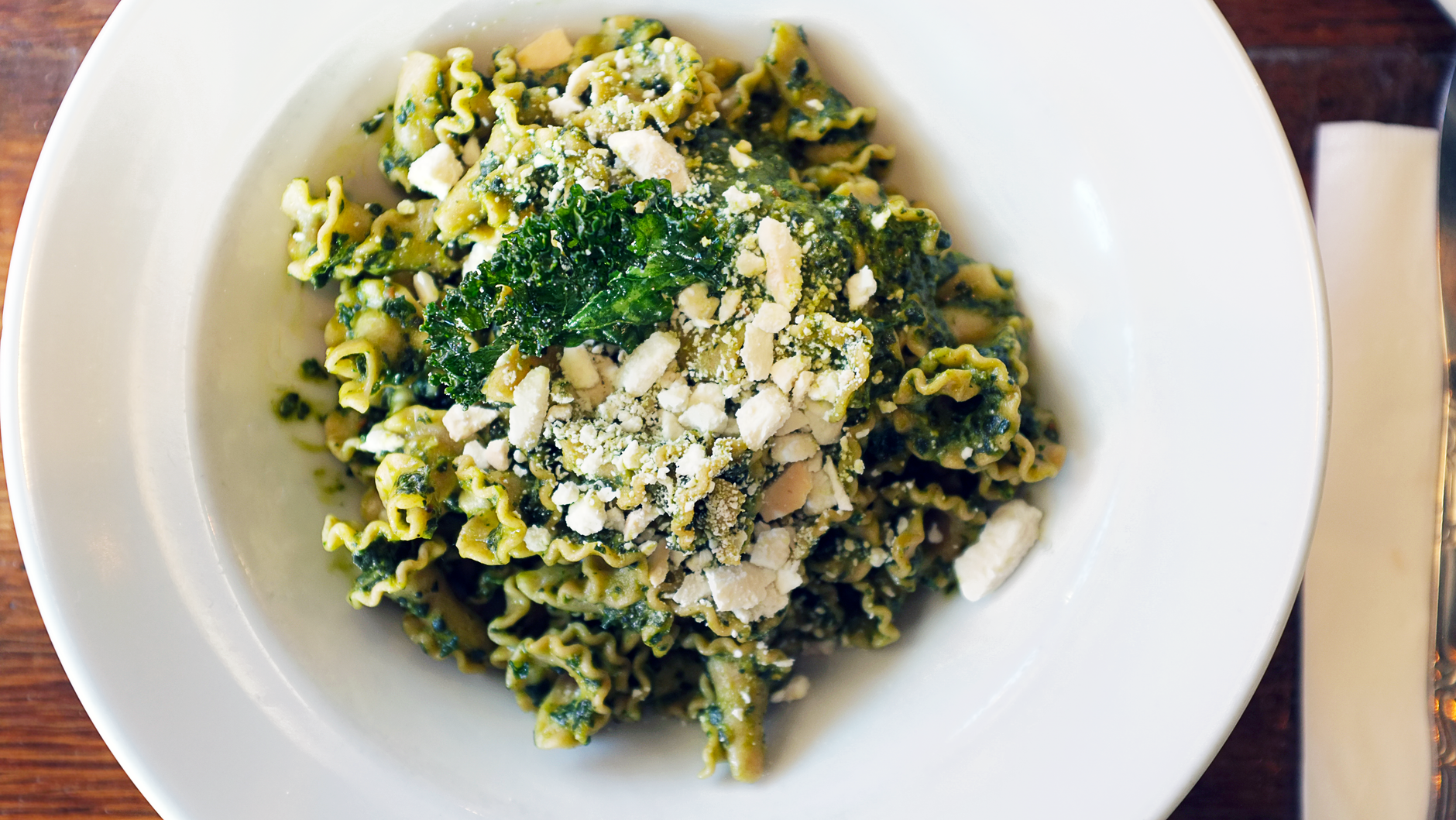 Fermentowane pesto z jarmużu: dłuższa trwałość i głębszy umami Makaron z zielonym pesto i tartym serem na talerzu