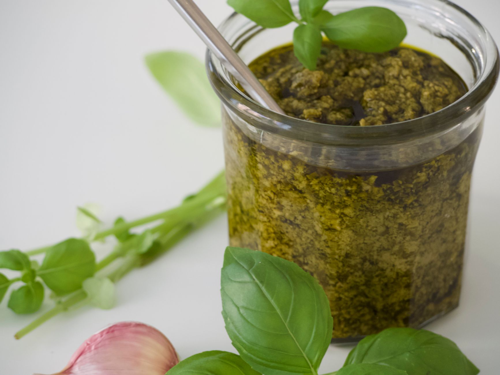 Zbliżenie na świeże domowe pesto z liśćmi bazylii i czosnkiem