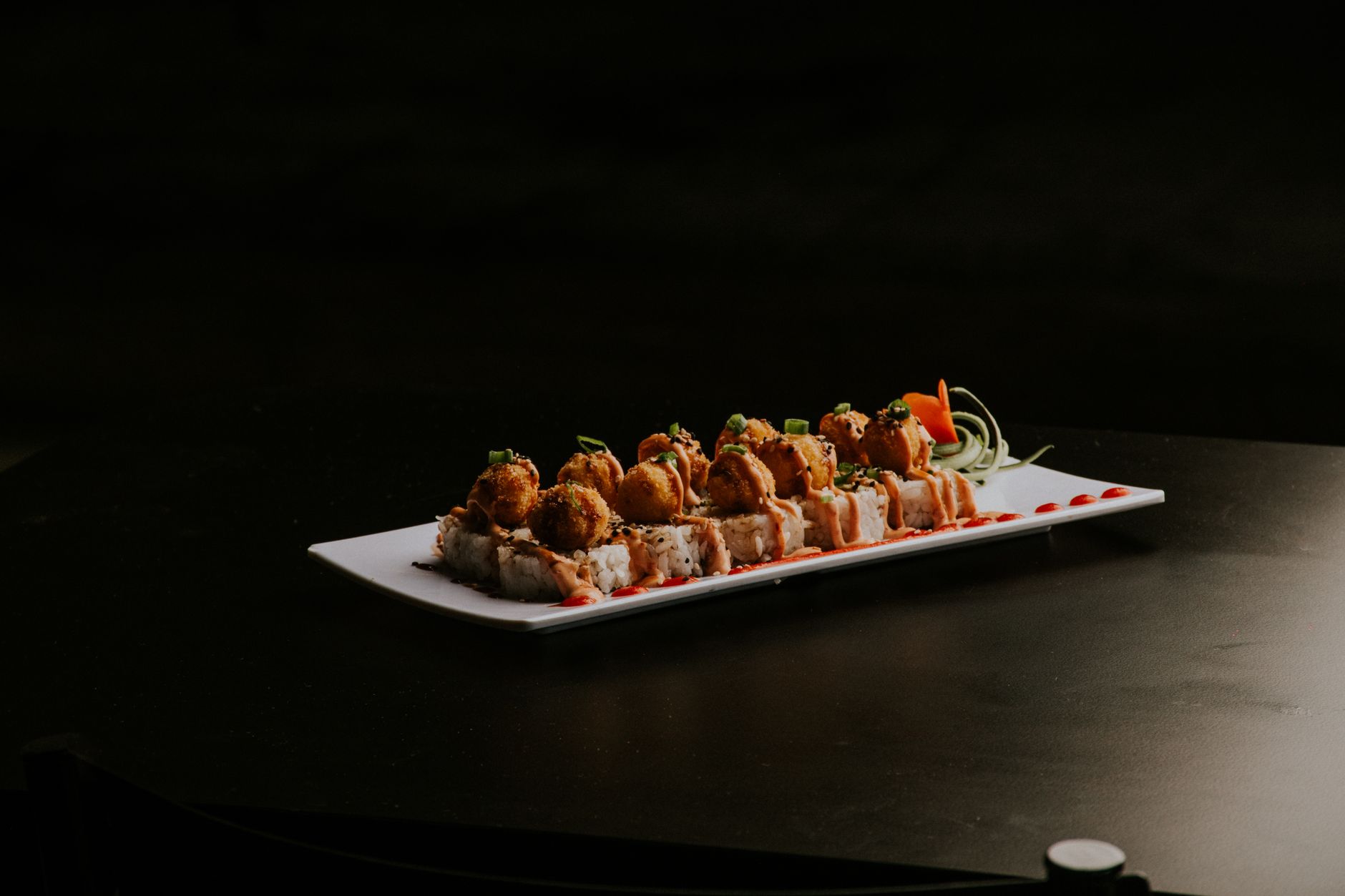 Sushi z warzywami i chrupiącą tempurą na czarnym tle